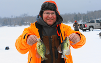 image of ice fisherman holding 2 crappies