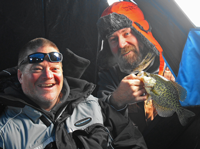 image of 2 ice fishermen holding crappies